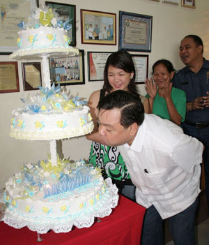 Mayor Jerry Trenas blowing cake