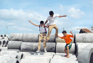 Young boys play on top of the concrete pipes stacked in a vacant lot in Brgy. Nabitasan, Lapaz