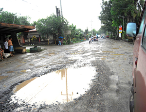 Big potholes scatter along a national road near Passi City