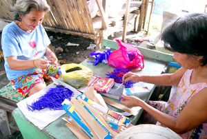 Two elderly women help make firecrackers in Arevalo district, the firecrackers and fireworks capital of Iloilo City.
