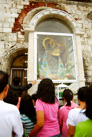 Devotees offer flowers, candles and prayers to the “sacred” image of Nuestra Señora de la Candelaria at the Jaro Cathedral.