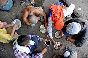 Fishermen in Cadiz City eat their meal of rice and fish to energize them before setting sail again.
