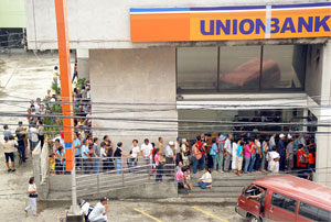 Government Service Insurance System (GSIS) members swarm outside the Union Bank in Iznart Street, Iloilo City