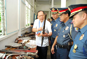 Iloilo Governor Niel Tupas Sr. examines one of the loose firearms recovered