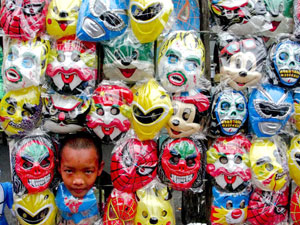 A boy inserts his head among different kinds of masks sold in downtown Bacolod City.