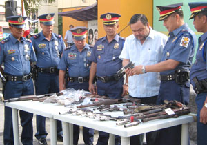 Iloilo City Police Office (ICPO) director Senior Supt. Melvin Mongcal presents to Mayor Jerry Treñas several unlicensed firearms