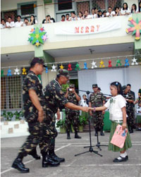 Major General Vicente Porto, commander of the 3rd Infantry Division, shakes the hand of a grade school student after she read her Christmas card to the soldiers of the Philippine Army from all over Panay Island. Also in photo is Major General Josue Solo Gaverza Jr., vice commander of the Philippine Army.