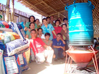 NEEDMPC officials and OPA staff led by Mushroom Culture Specialist Alexander Lecciones (in blue shirt) with the drum sterilizer, rice hull stove and sacks of rice hull at foreground.