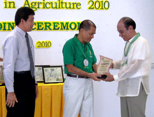 Rufino S. Suelo (right) of Zarraga, Iloilo receives a trophy citing him as Outstanding Agri-Achiever