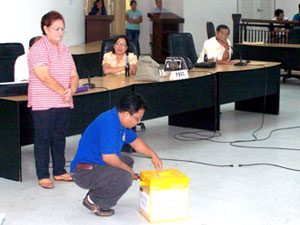 An election officer opens the ballot box containing the back-up CD of the election results in Tigbauan, Iloilo