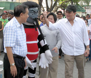 Provincial Administrator Raul Banias (right) raises a fist against the Aedes Aegypti mascot