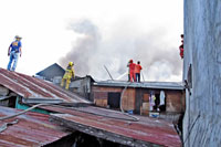Smoke billows from the fire that destroyed 53 houses in Brgy. Rizal Ibarra, City Proper confront firefighters Tuesday afternoon.