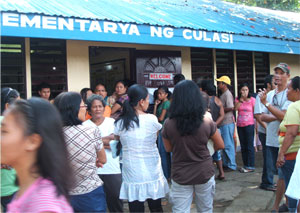 Voters in Brgy. Culasi, Roxas City line up outside the polling center, waiting to cast their votes yesterday.